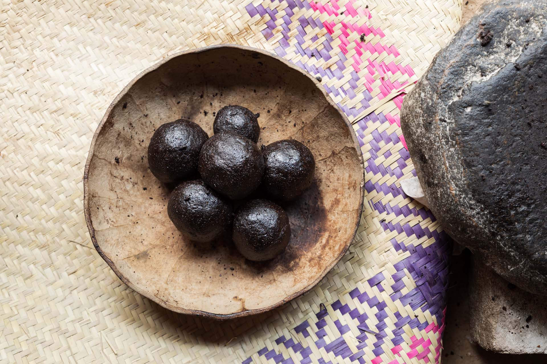 Bolitas de pasta de cacao sobre una jícara de totomoxtle, colocada sobre un petate con diseños tradicionales