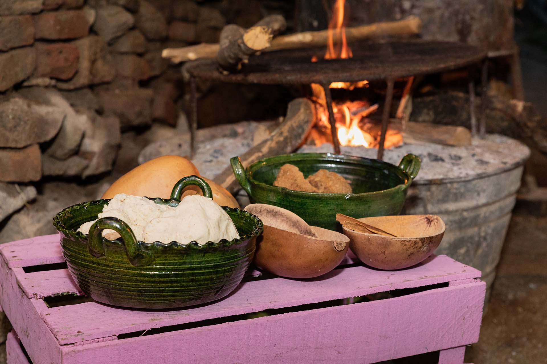 Ingredientes tradicionales para preparar el atole de sapo: masa de maíz, canela, panela y jícaras, sobre una mesa rústica en Oaxaca. Esta bebida forma parte de las 87 recetas documentadas en el libro Bebidas de Oaxaca